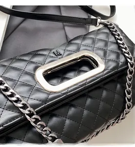 Detail einer schwarzen gesteppten Ledertasche mit goldener Schließe und M-Logo