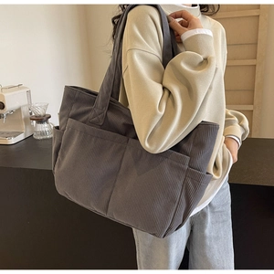 Détail du sac cabas en velours côtelé gris foncé avec plusieurs poches et texture rayée