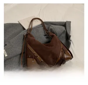 Detail of dark brown hobo bag featuring lace-up side design and matte suede texture