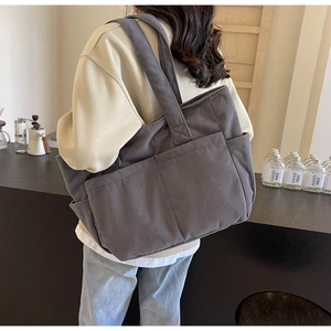Gros plan sur la texture en velours côtelé et les grandes poches du sac gris