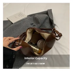 Detailed interior view of brown PU leather shoulder bag showing large capacity storage