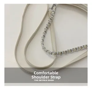 Detail of beige shoulder bag showing comfortable leather strap and silver metal chain link