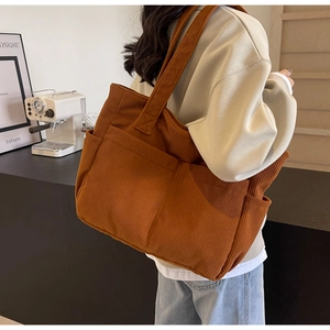 Détail du sac cabas en velours côtelé caramel avec plusieurs poches et texture rétro