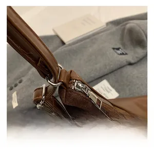 Close-up of silver hardware zippers and mixed texture leather on a vintage bag