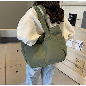 Détail du sac fourre-tout en velours vert montrant la capacité et la poche latérale
