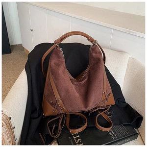 Detail of dark brown matte suede hobo bag with smooth leather trim and side lacing