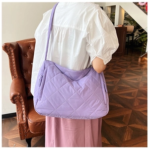Detailed view of the purple quilted nylon tote bag with puffer padded diamond texture