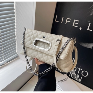 Detail der gesteppten cremefarbenen Lederhandtasche mit silbernem Hohlgriff und Kettenriemen
