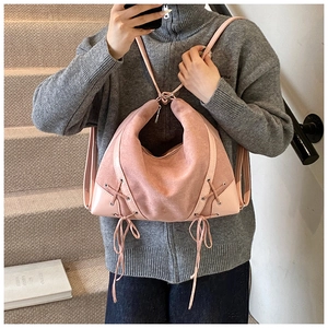 Detail of pink vintage backpack with side lace-up design and matte suede texture
