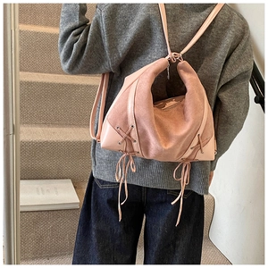 Detail of dusty rose backpack with matte texture and decorative crisscross side lacing