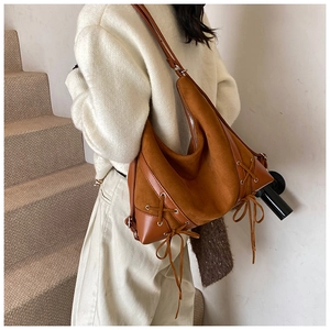 Detail of caramel suede and smooth leather bucket bag with side drawstring and silver zipper