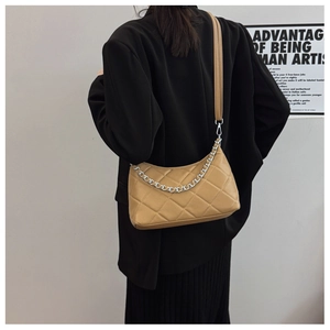 Close-up of khaki quilted half-moon bag featuring a stylish silver chain and leather strap