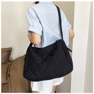 Close-up of black quilted nylon tote bag showing soft puffer texture and diamond pattern
