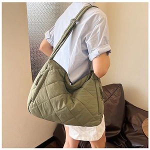 Detailed macro view of grass green quilted tote bag with adjustable wide shoulder strap