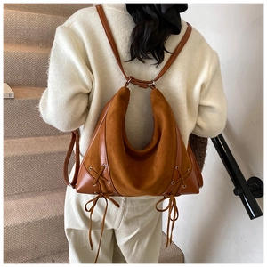 Detail of caramel faux suede backpack showing cross-lace design and integrated straps