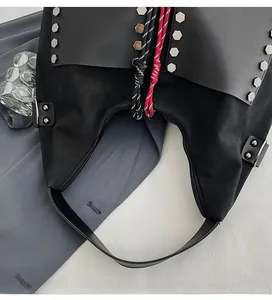 Detail view of black bucket bag featuring silver hex rivets and colorful rope accents