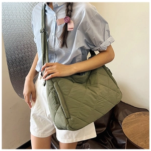 Detail of army green quilted puffer tote bag with adjustable strap and zip pocket