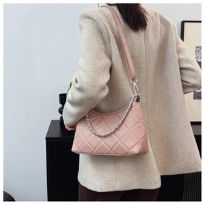 Detail of light pink quilted crossbody bag with stylish silver chain and leather strap