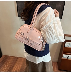 Détail du sac à bandoulière en cuir verni rose avec nœud et boucle en argent