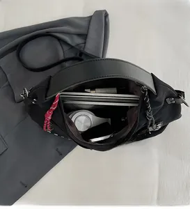 Spacious interior of a black matte tote bag showing storage for laptop and headphones