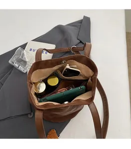Interior view of brown bucket tote bag showing large capacity and multi-pocket design