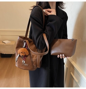 Detailed set of brown leather tote bag with small zipper pouch and cute dog charm detail