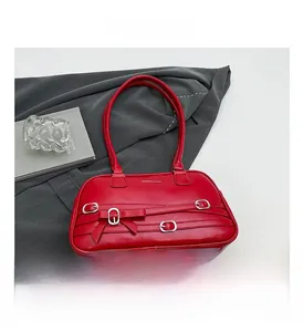 Détail du sac à main rouge en similicuir avec sangles, œillets argentés et nœud