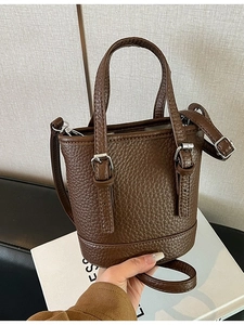 Deep brown lychee textured leather bucket bag with silver buckles and dual top handles