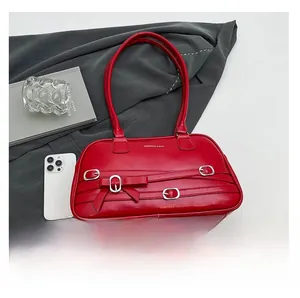 Détail du sac à bandoulière en cuir rouge avec boucles argentées et nœud élégant