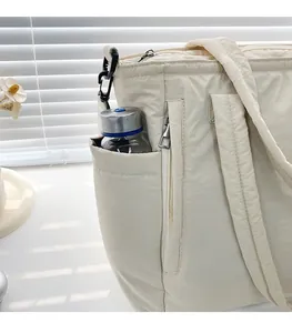 Detail der Seitentasche mit Wasserflasche und Reißverschluss an cremefarbener Nylontasche