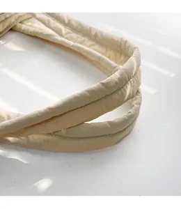 Detail der wattierten Steppgriffe einer beigen Nylon-Tragetasche mit Baumwollfüllung
