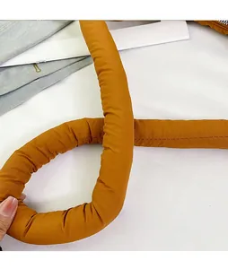 Detail of a padded brown nylon shoulder strap with reinforced horizontal stitching