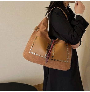 Detail of vintage brown bucket bag with metallic rivets and braided rope accents
