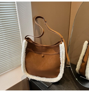 Detail of vintage brown suede bucket bag with white faux fur trim and leather strap