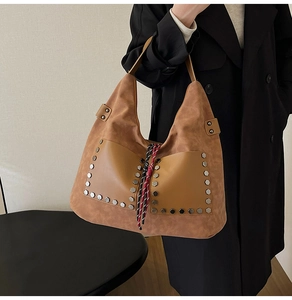 Detail of vintage matte brown tote bag with metal rivets and decorative woven rope