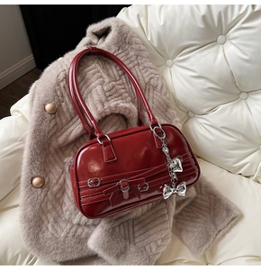 Vue détaillée du sac sous le bras rouge vin brillant avec pendentif coeur argent