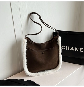 Detail of dark brown suede shoulder bag featuring plush white faux fur trim and strap