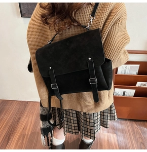 Detail of black matte suede backpack showing retro buckle straps in a British style look