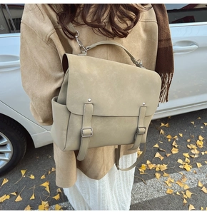Detalle de mochila de cuero mate en tono tierra con hebillas plateadas en estilo otoñal