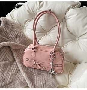 Vue détaillée du sac en similicuir rose avec nœud et pendentif cœur en argent