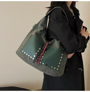 Detail of dark green matte tote bag with silver rivets and colorful braided cord