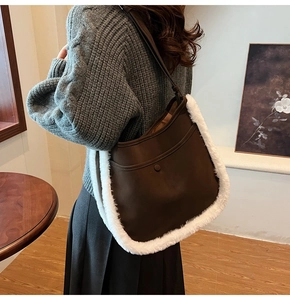 Detail of dark brown faux suede bucket bag with white plush trim and front snap pocket