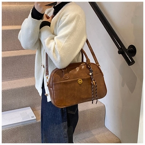Detail of vintage dark brown PU leather Boston bag with metal twist lock and texture