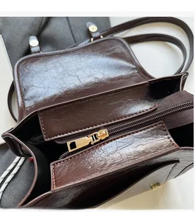 Detail of smooth golden metal zipper and glossy vintage brown leather inner pocket