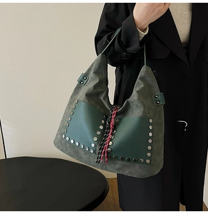 Macro detail of retro green hobo bag featuring silver rivets and braided tassels