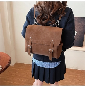 Detalle de mochila vintage de cuero PU marrón mate con hebillas plateadas y diseño clásico