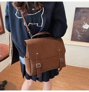 Detalle del bolso mensajero vintage marrón oscuro con asa y hebilla de metal plateado