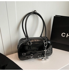Détail d'un sac à bandoulière en cuir verni noir brillant avec nœud élégant