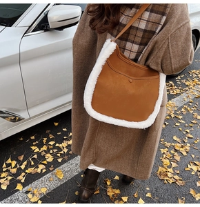 Detailed view of brown faux suede shoulder bag with white faux fur trim and snap button