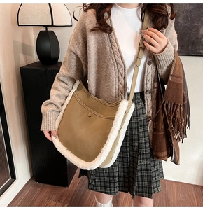 Detail of suede bucket bag with white faux fur trim and adjustable shoulder strap